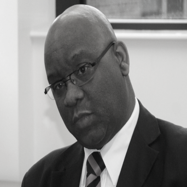 A monochrome image featuring a man in a formal suit and tie, capturing a classic and sophisticated look.