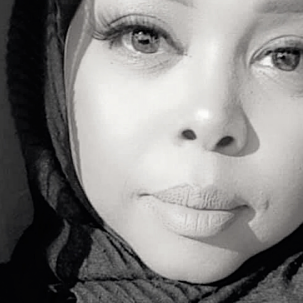 A woman with a black headscarf, showcasing elegance and cultural significance in her attire.